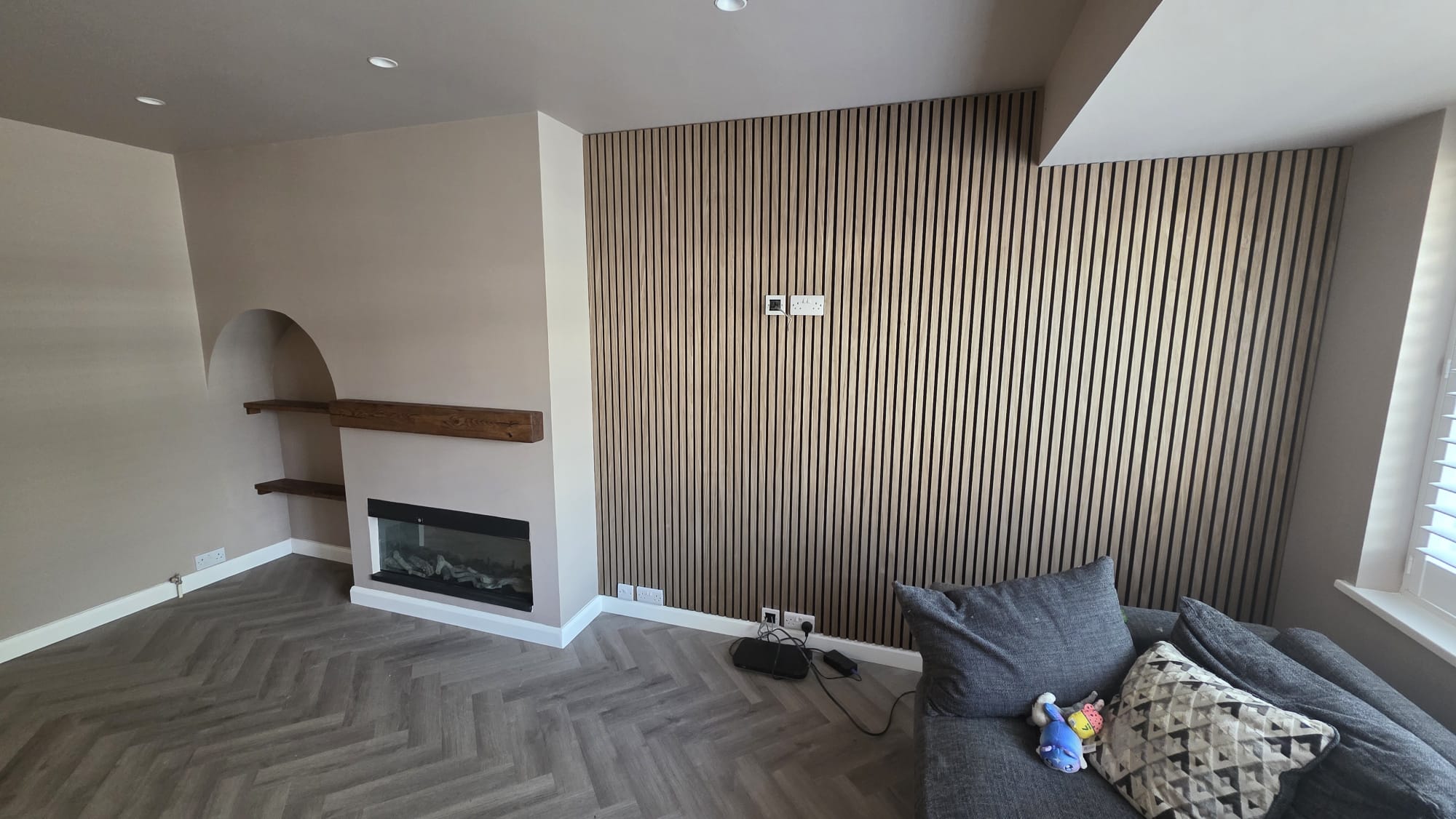 The same living room after the new bespoke media wall and slatted feature wall were installed
