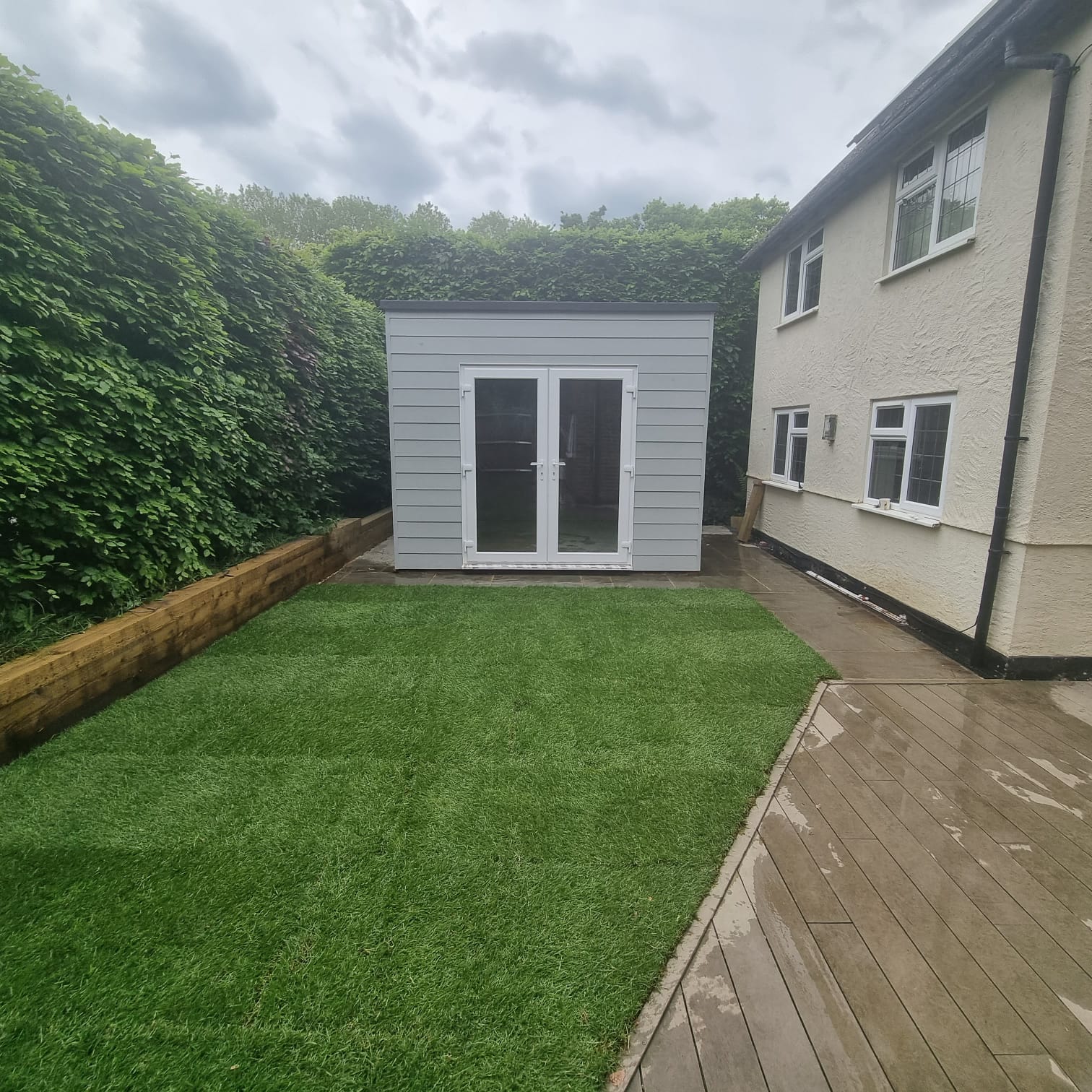 Completed insulated garden room in a Surrey back garden with cladded exterior