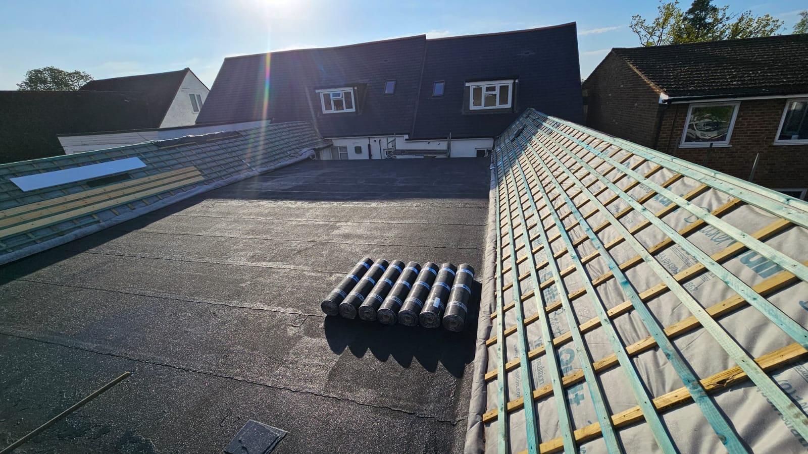 Aerial view of a large slate and felt roof mid-installation on a Surrey property