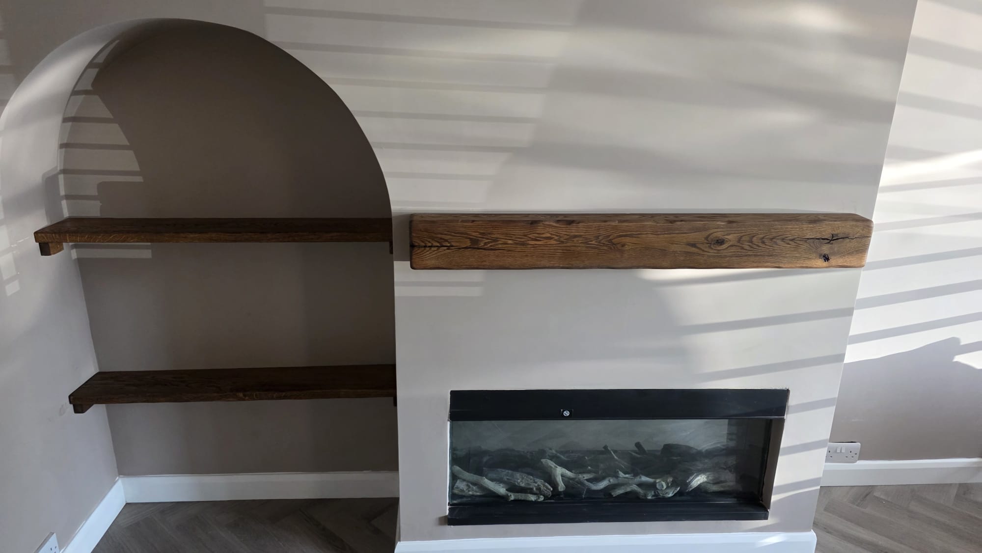 Bespoke media wall with wooden mantel, electric fireplace and integrated TV