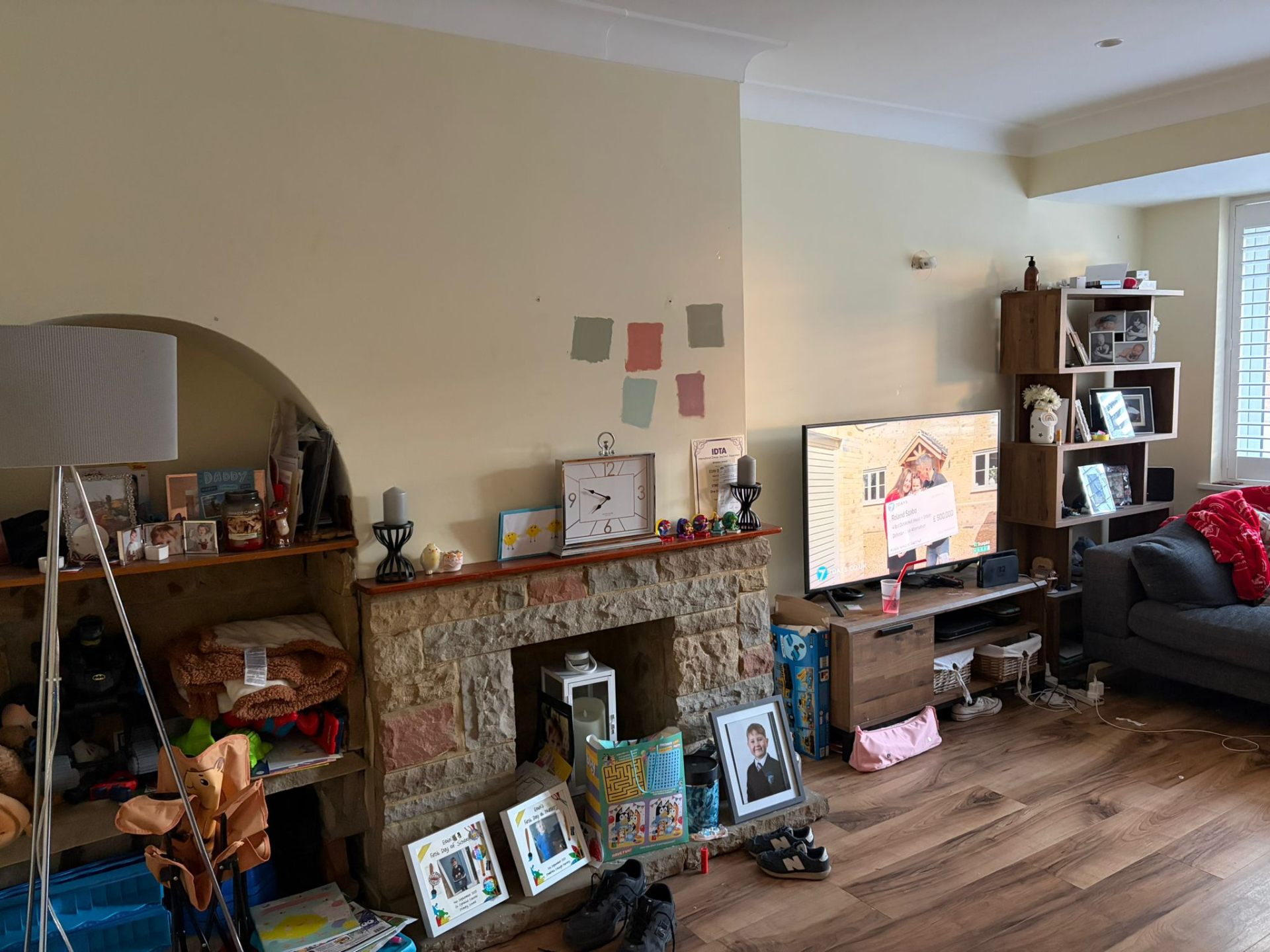 Living room before renovation with an old stone fireplace and dated yellow walls